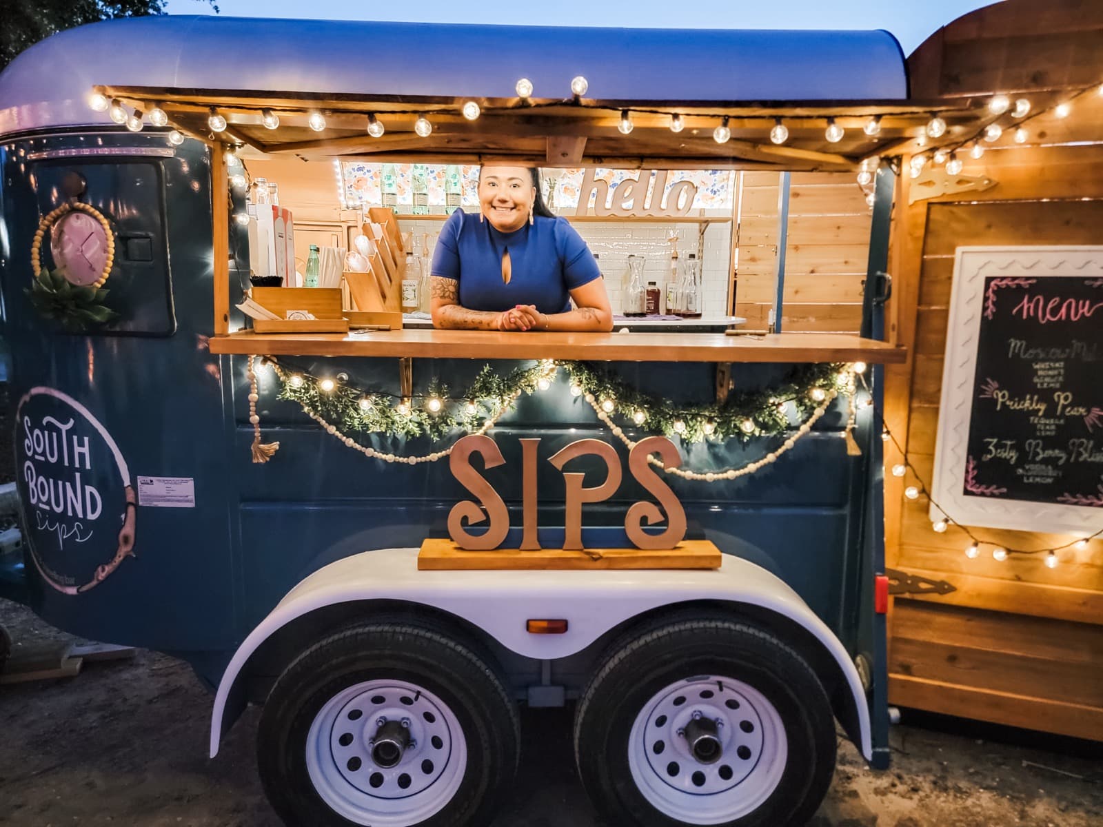 Southbound Sips mobile bar bartender serving at night event with string lights